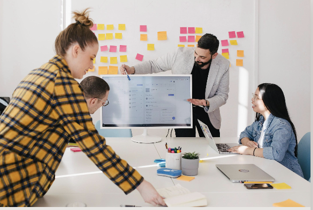 A team mapping a go-to-market plan on a whiteboard covered in sticky notes.
